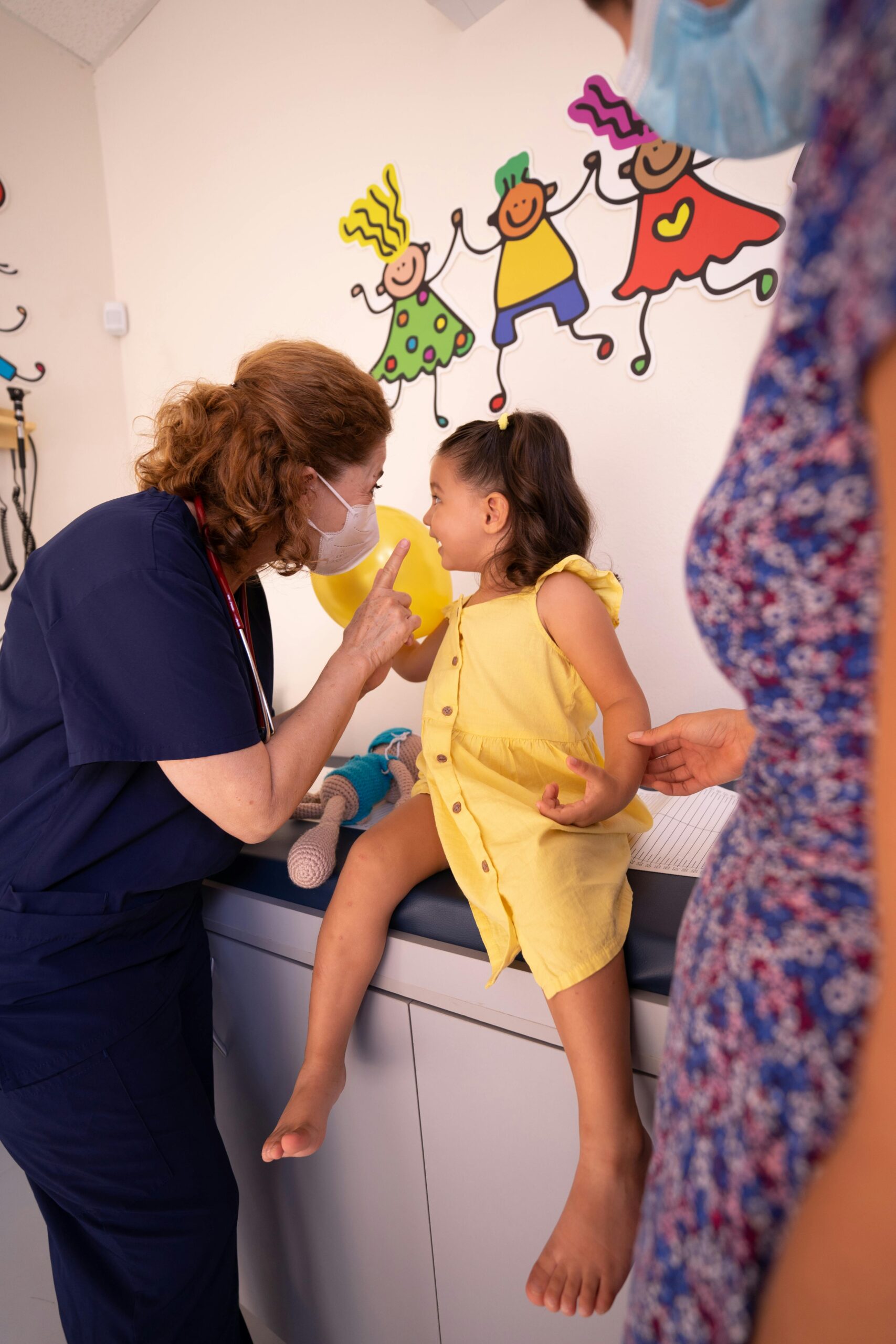 A woman in blue scrubs is holding bananas