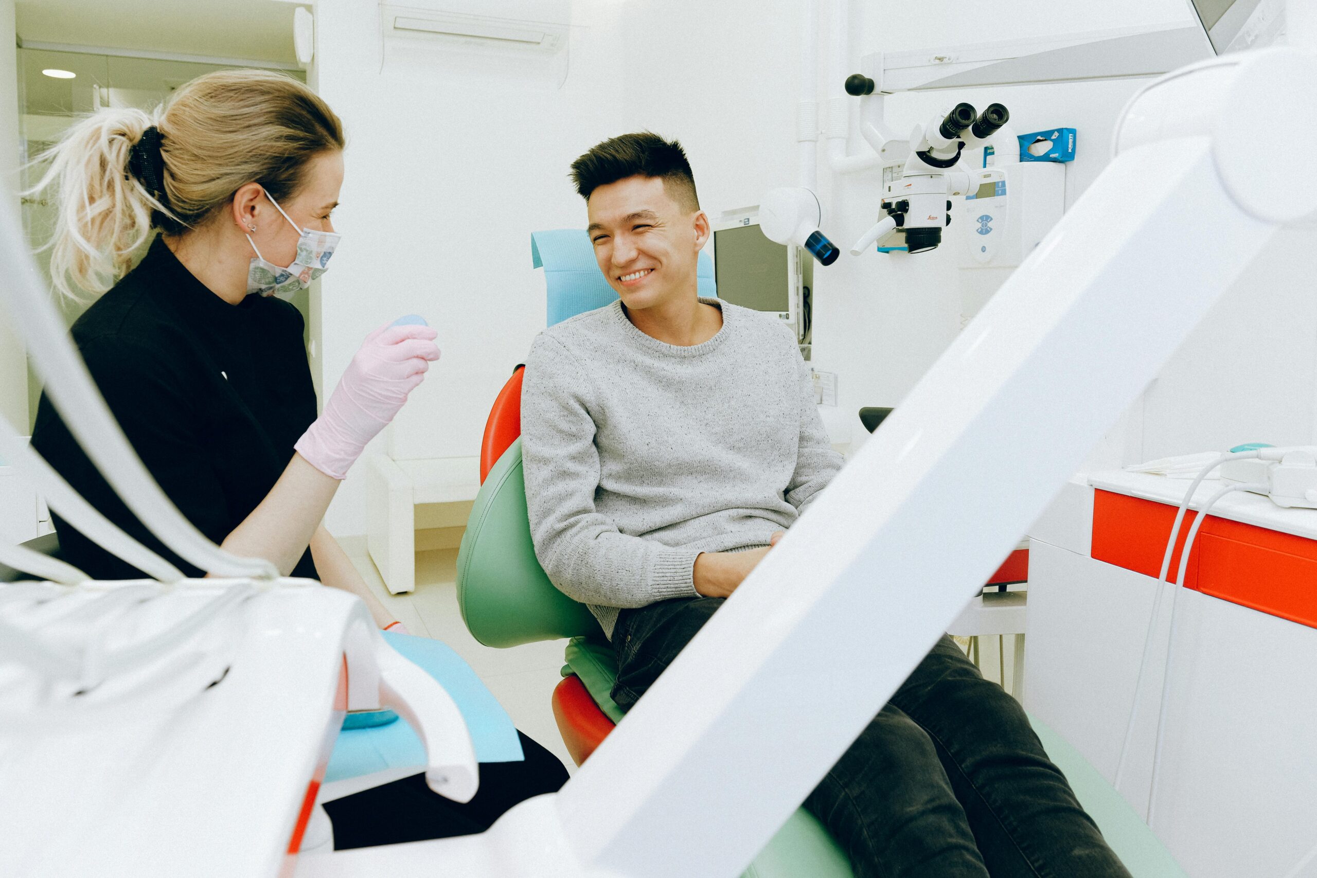 A man sitting in the dentist chair with his teeth.