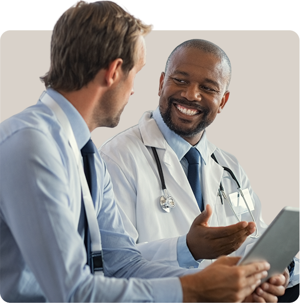 Two doctors are talking to each other while holding a tablet.