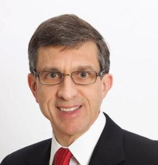 Man in suit and tie, wearing glasses.