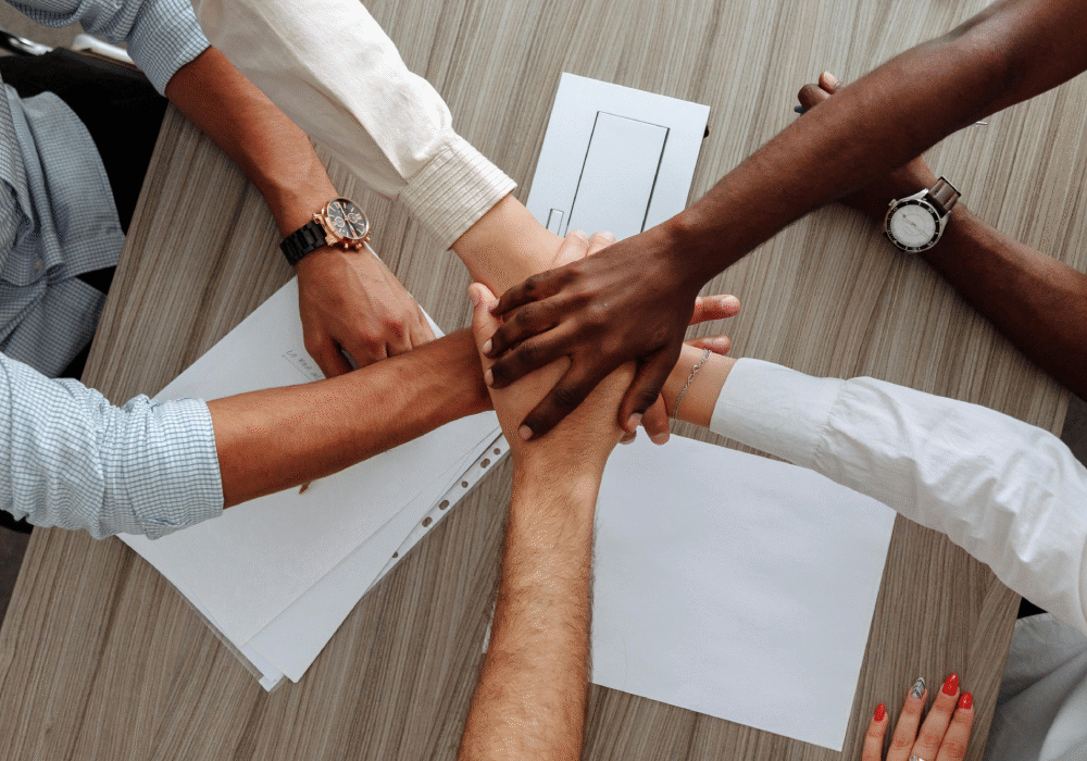 A group of people holding hands in the middle of a circle.