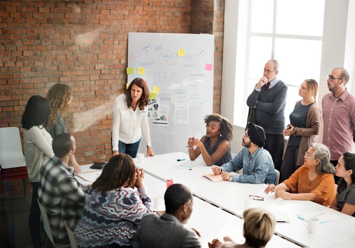 Team meeting with whiteboard discussion.